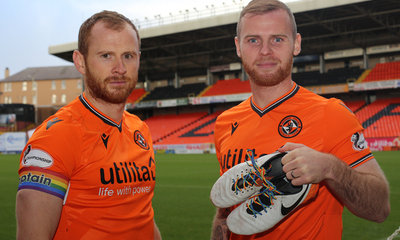 mark reynolds and mark connolly hold up the boots showing our support for rainbow laces